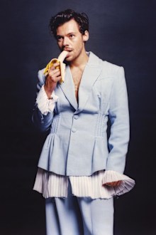 Harry Styles pokes fun at Candace Owens with a photo of him eating a banana in a powder blue frilly suit.
