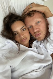 Emily Ratajowski and her husband Sebastian Bear-McClard lying in bed.