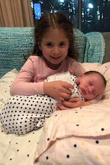 Evie holding her baby brother after his homecoming.
