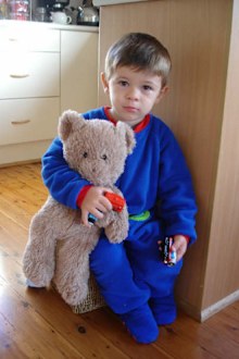Isaac as a toddler holding a teddy bear