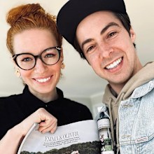 Emma Watkins with husband Oliver Brian holding their wedding spread.