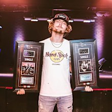 Bailey Zimmerman poses with his certified platinum singles.