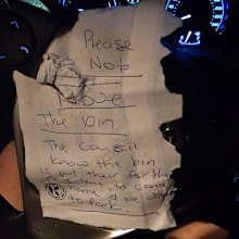 The handwritten note tells the driver their bin reserved the parking spot in Glebe