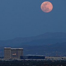 LAS VEGAS, NEVADA - APRIL 07:  The super pink moon, the biggest supermoon of the year, rises over (L-R) Delano Las Vegas at Mandalay Bay Resort and Casino, Mandalay Bay Resort and Casino, the under construction Allegiant Stadium and McCarran International Airport on April 7, 2020 in Las Vegas, Nevada. The pink moon got its name because the April full moon occurs at the same time as the pink wildflower Phlox subulata blooms in North America. A supermoon occurs when a full moon coincides with its 