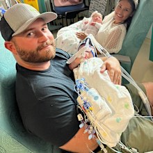 Sandy and Jesse each holding their twin daughters after their marathon six hour surgery.