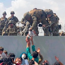 A baby being lifted across a wall at Kabul Airport in Afghanistan by US soldiers, during chaotic scenes last week.