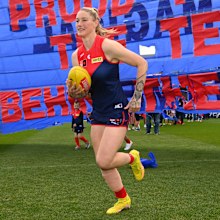 Tayla Harris of the Demons runs through the banner during the round seven AFLW match between the Melbourne Demons and the Western Bulldogs at Casey Fields on October 09, 2022 in Melbourne, Australia.