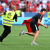 A pitch invader is chased by a steward.