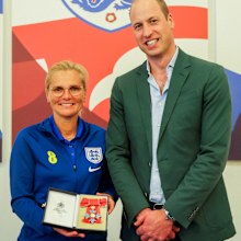 Prince William, Prince of Wales and President of The Football Association, gives an honorary CBE to England manager Sarina Wiegman during a visit to England Women's team to wish them luck ahead of the 2023 FIFA Women's World Cup at St Georges Park on June 20, 2023 in Burton-upon-Trent, England 