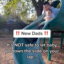 Dad going down slide with baby. 