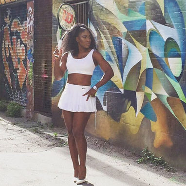 Serena strikes a pose in a daringtwo-piece tennis outfit.