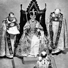 In 1953, the Coronation of Queen Elizabeth II took place at Westminster Abbey. Her Majesty is pictured during the Crowning Ceremony, seated on the Coronation Chair, wearing the St. Edward Crown and carrying the Sovereign's Sceptre and Rod.