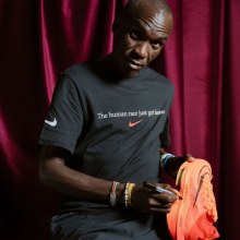 Eliud Kipchoge signs a pair of Nike Air Zoom Alphafly Next%.