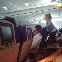 child jumping on tray table during flight