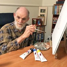 Malcolm works on his Archibald Prize entry while isolating in his room at Estia House.