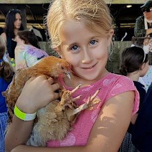 Laura Everson as a child holding a chicken.