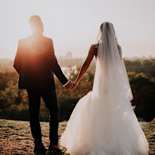 Bride and groom holding hands.
