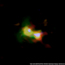 Composite image of B14-65666 showing the distributions of dust (red), oxygen (green), and carbon (blue), observed by ALMA and stars (white) observed by the Hubble Space Telescope