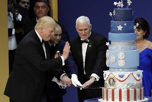 Image: Getty. Trump cuts the controversial inauguration cake during the Armed Services Inaugural Ball in Washington, D.C., on Friday, Jan. 20, 2017