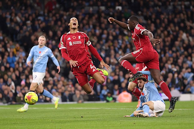 Virgil van Dijk of Liverpool is challenged by Bernardo Silva of Manchester City.