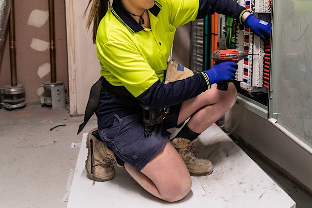 A female tradesperson working on an electrical circuit. 