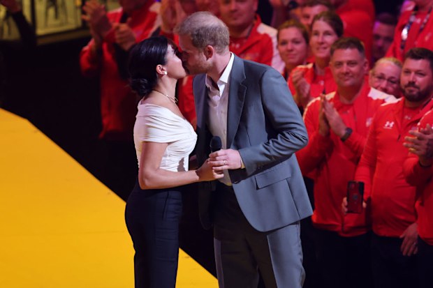 Prince Harry and Meghan Markle share a kiss on stage at the 2022 Invictus Games