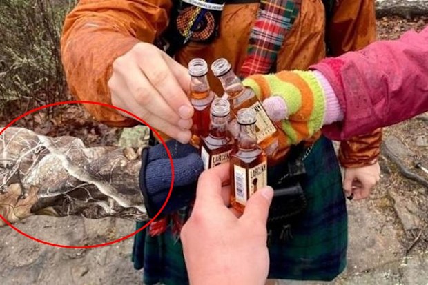 On closer inspection, you can see the fourth man is wearing cammo gear that completely obscures him from view.