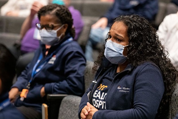 Nurse cries after finding out she and thousands of healthcare workers will receive surprise, free vacations from Hyatt and American Airlines. 