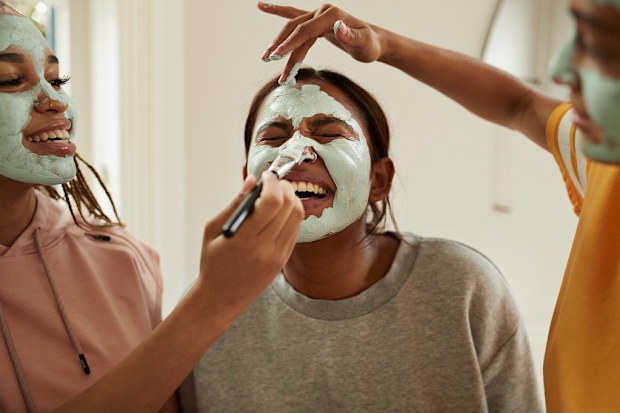 Girls applying cosmetic face masks.