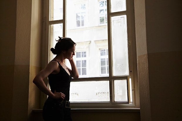 Anxious woman standing at window.
