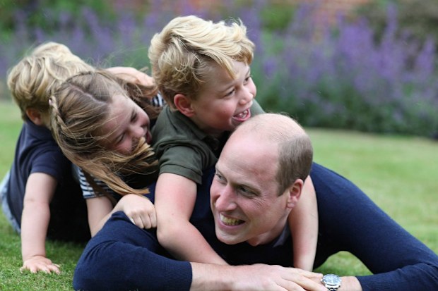 George plays with his dad and siblings at the family home.