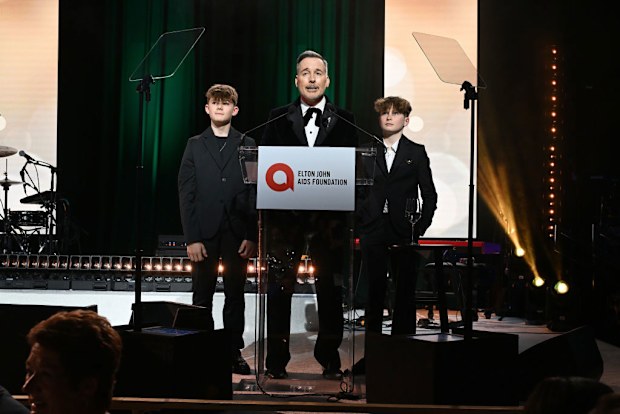WEST HOLLYWOOD, CALIFORNIA - MARCH 02: (Exclusive Coverage) (L-R) Zachary Furnish-John, David Furnish and Elijah Furnish-John speak onstage during Elton John AIDS Foundation's 33rd Annual Academy Awards Viewing Party on March 02, 2025 in West Hollywood, California. (Photo by Michael Kovac/Getty Images for Elton John AIDS Foundation)