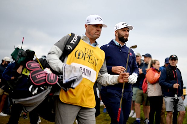 Jon Rahm of Spain walks alongside his caddie.