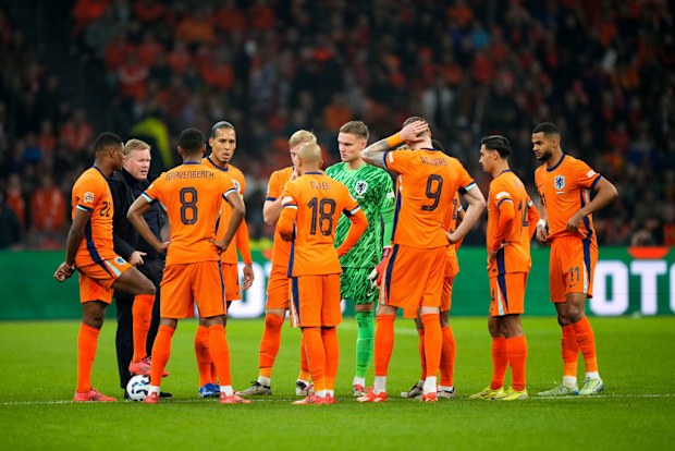 Coach Ronald Koeman of Holland talks to his players during the medical emergency treatment of assistant trainer Adam Szalai.