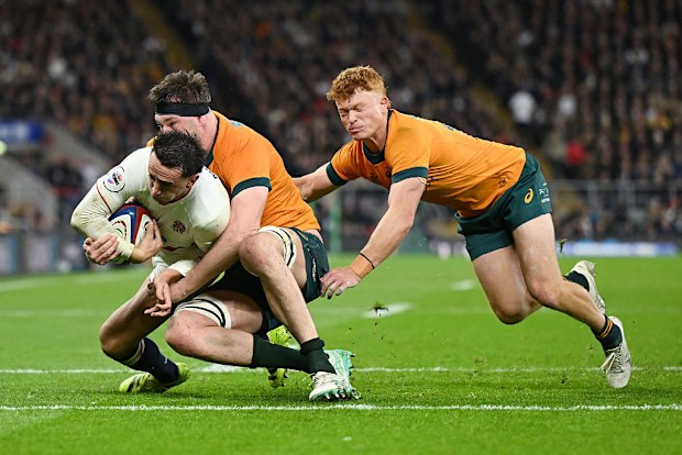 Alex Mitchell de Inglaterra hace tacleadas de Nick Frost y Tane Edmed.