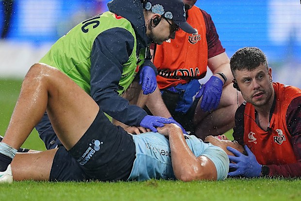 Joseph-Aukuso Suaalii of the Waratahs receives treatment for an injury before being stretchered off.