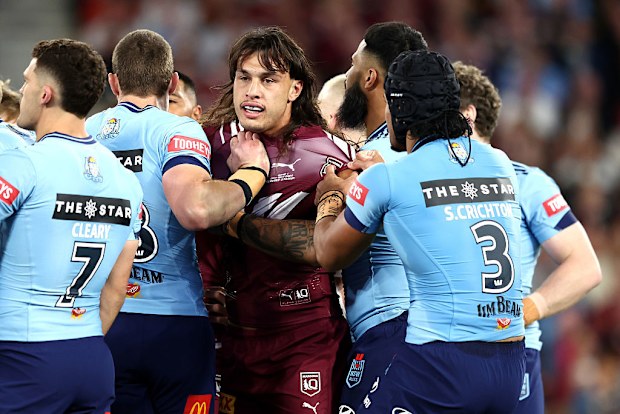     Tino Fatuswamalui de Maroon es tirado por jugadores de Blues de NSW. 