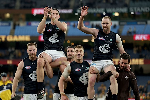 Jacob Weitering is chaired off the ground following his 200th game and Sam Docherty following his final game.