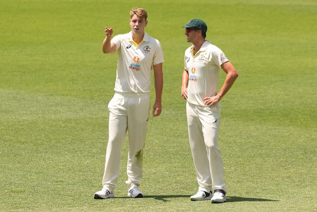 Cameron Green of Australia and Pat Cummins of Australia discuss fielding placements.
