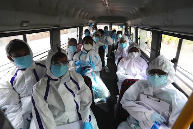 Health workers arrive on a bus to conduct a free medical checkup at residential building in Mumbai, India.