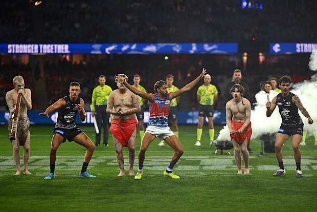Carlton's Jack Ison and Zac Williams and Arthur Jones of the Bulldogs take part in the pre match ceremony.