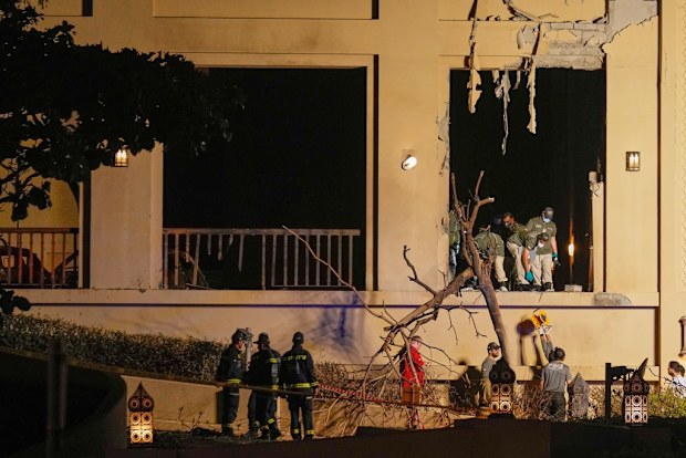 Firemen and rescue workers inspect the site of an explosion at the Fairmont The Palm Hotel in Dubai, United Arab Emirates, Saturday, Feb. 28, 2026. (AP Photo/Altaf Qadri)