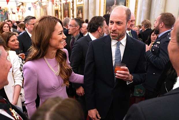 Catherine, Princess of Wales places a hand on her the Prince of Wales's back at a reception at Buckingham Palace to mark 100 years since the birth of Queen Elizabeth II on April 21, 2026.