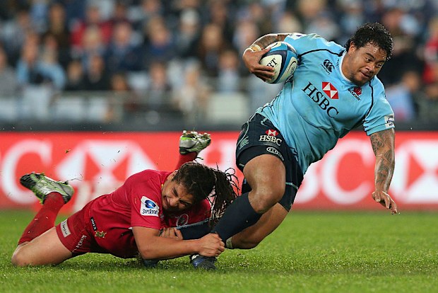 John Ulugia of the Waratahs is tackled.