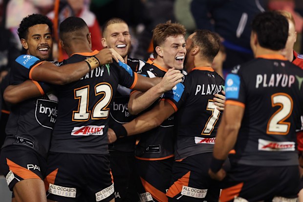 Lachlan Galvin of the Tigers celebrates with team mates after scoring a try.