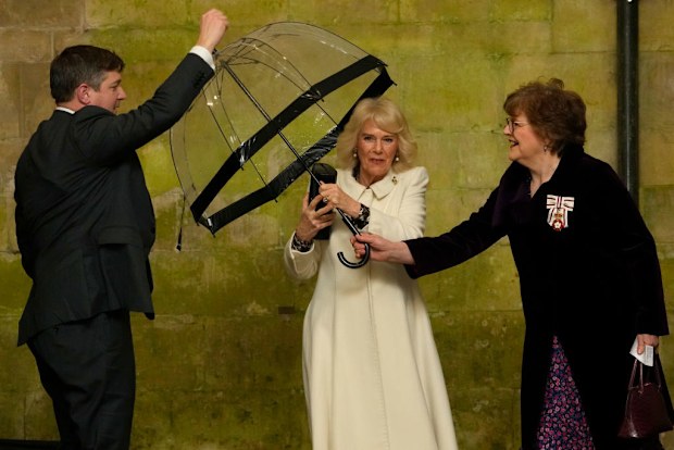 Britain's Queen Camilla hands her umbrella to an aide as he arrives to attend a Musical Evening at Salisbury Cathedral, Salisbury, England, Thursday, Feb. 8, 2024, to celebrate the work of local charities. (AP Photo/Kirsty Wigglesworth, Pool)