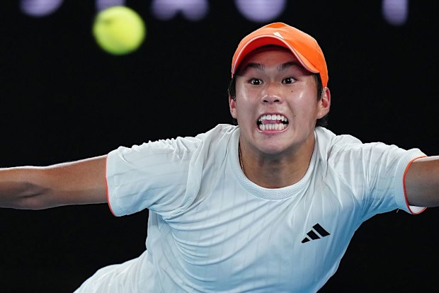 Learner Tien of the United States looks at the ball against Alexander Zverev of Germany.