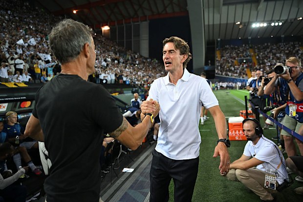 Thomas Frank Louis da la mano con Enric.