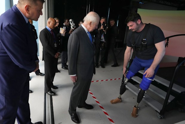 King Charles III speaks to David Henson a former soldier and Paralympian