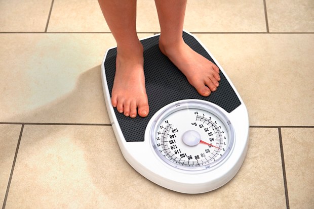 Child weighing themselves at home